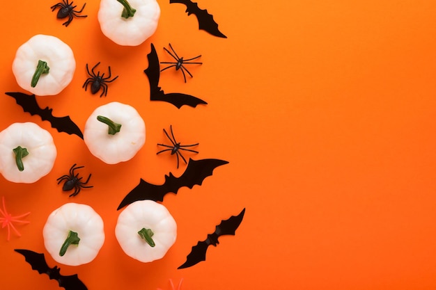 Оранжевый фон хэллоуина стая черных летучих мышей, скелет тыквы паука и листья для хэллоуина силуэты черных бумажных летучих мышей на оранжевом фоне осеннее украшение концепция хэллоуина вид сверху