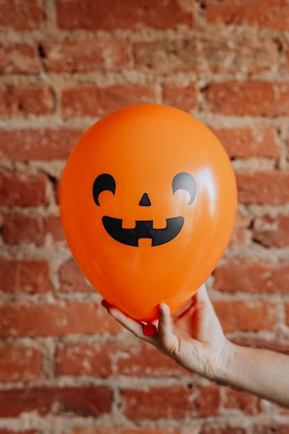 Orange Halloween balloon on a hand