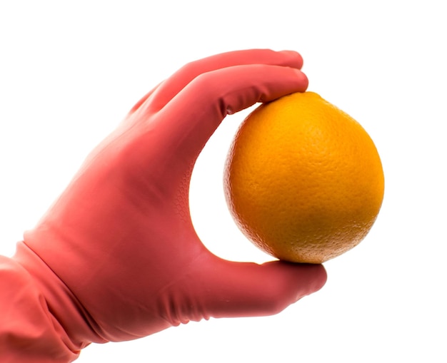 Orange in a hand in a rubber glove on a white background isolated the concept of harmful substances genetically modified fruits