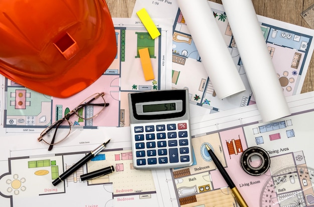 Orange helmet, construction drawing, calculator, pen