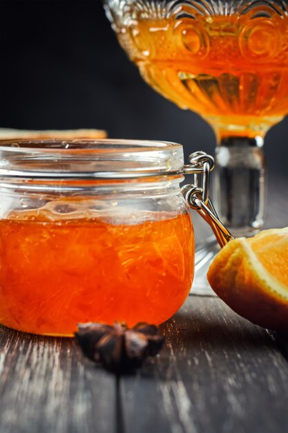 Orange jam in glass jar on wooden 