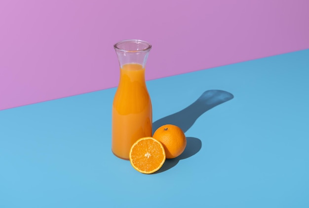 Orange juice carafe and orange fruits isolated on a vibrant background