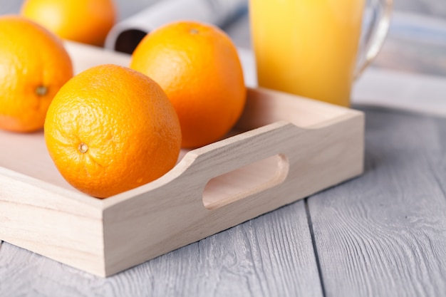 Orange juice in glass and fresh fruit on a wooden