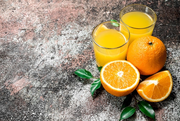 Orange juice in a glass of fresh oranges