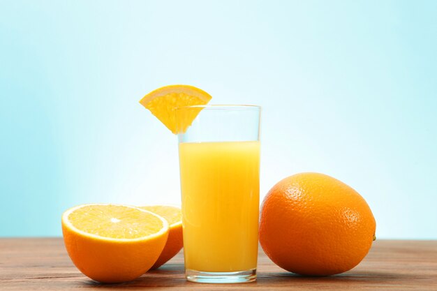 Orange juice in a glass oranges and orange slices on the table