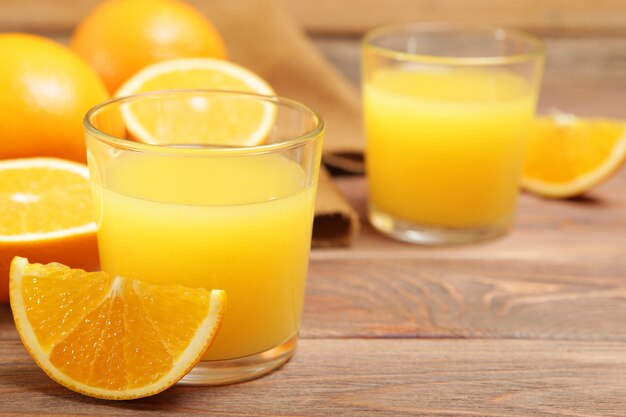 Orange juice in a glass oranges and orange slices on the table