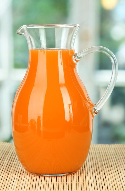 Фото Апельсиновый сок в кувшине на столе в комнате