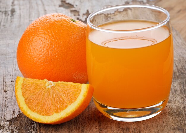 Orange juice and orange on wood