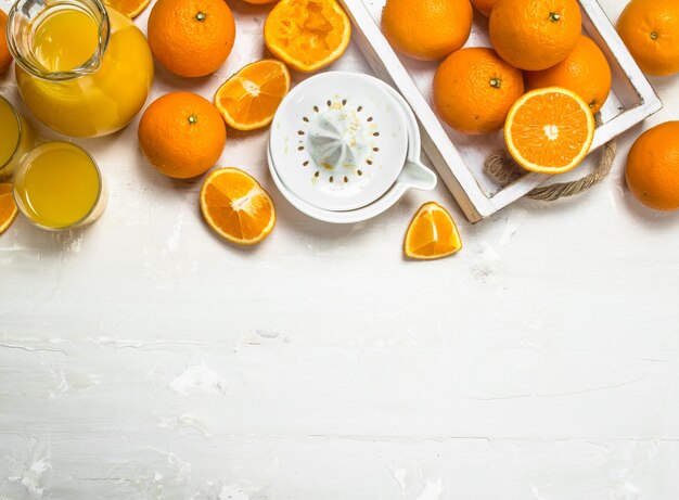 Orange juice in pitcher and juicer