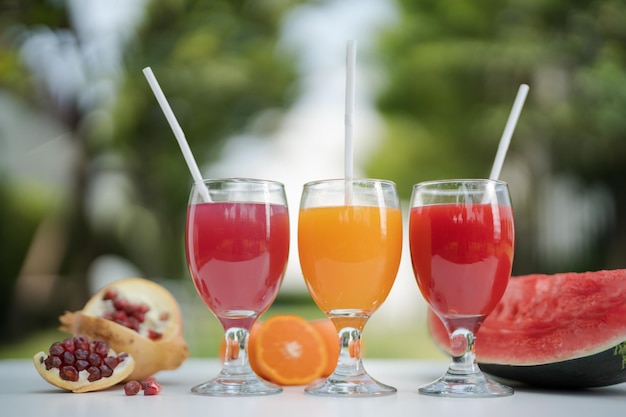 Апельсиновый сок, гранатовый сок и арбузный сок на естественном фоне