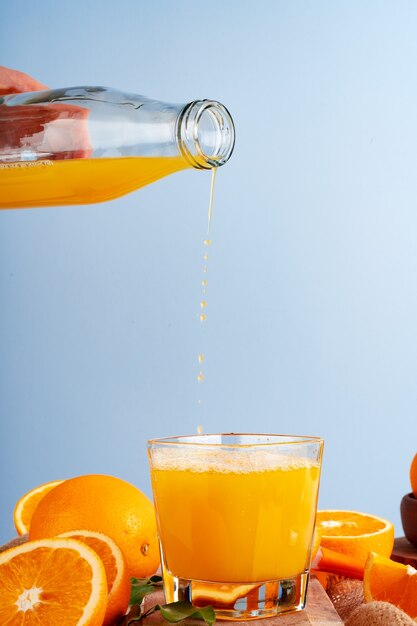 Orange juice pouring from the bottle into the glass