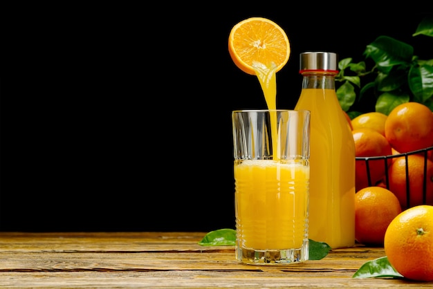 Orange juice pouring into glass on dark background fresh organic orange juice