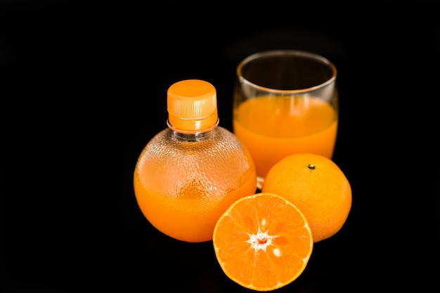 orange juice and slice isolated on black background