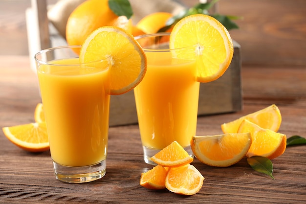 Orange juice on table on wooden background