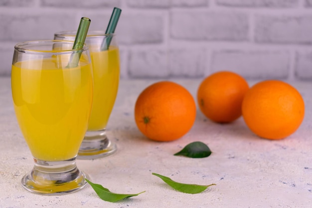 키 큰 유리잔에 담긴 오렌지 주스와 신선한 오렌지