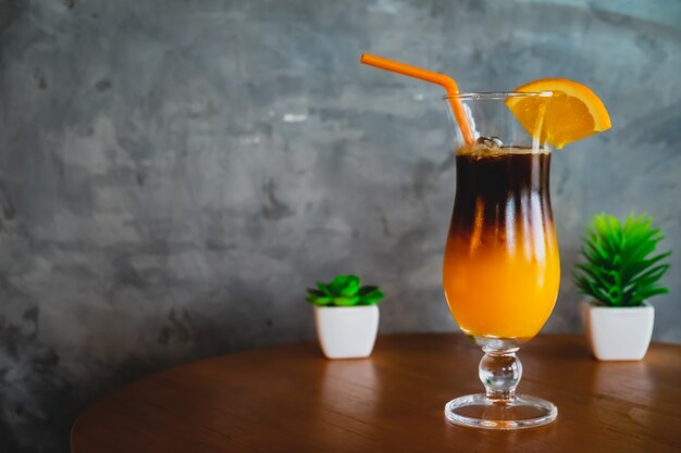 Photo orange juice with espresso shot on wooden table