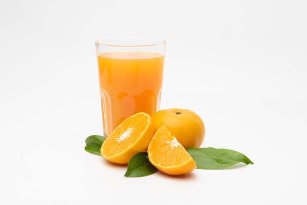  Orange juice with pulp and sliced fruits on white table.