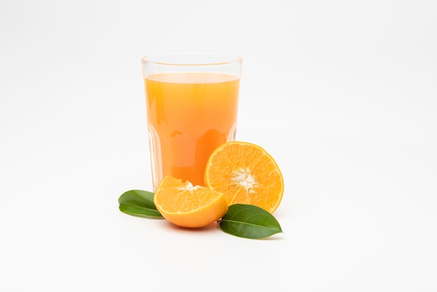  Orange juice with pulp and sliced fruits on white table.