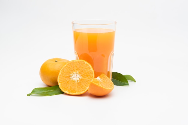  Orange juice with pulp and sliced fruits on white table.