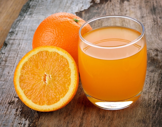 Orange juice on wooden background.