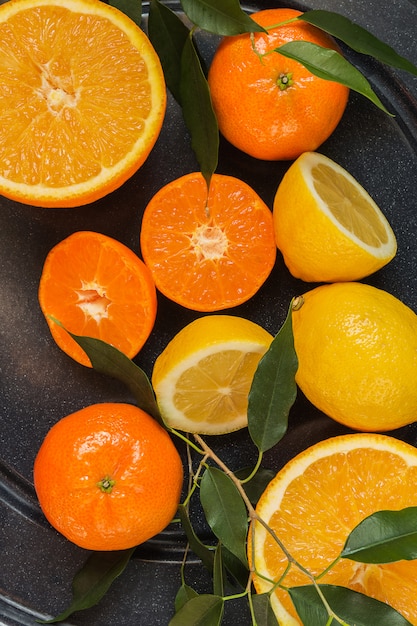 Orange, lemon, citrus fruits flat top view pattern on dark wooden background