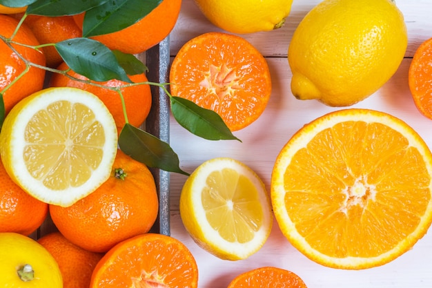 Orange, lemon, citrus fruits flat top view pattern on white wooden background