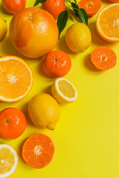 Orange, lemon, citrus fruits flat top view pattern on yellow background