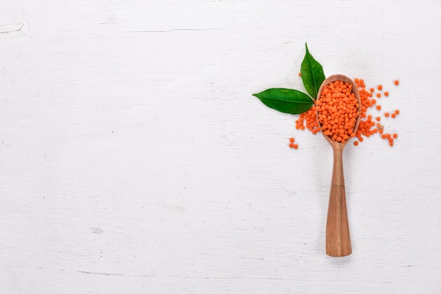 Orange lentils in a spoon On a wooden background Top view Copy space