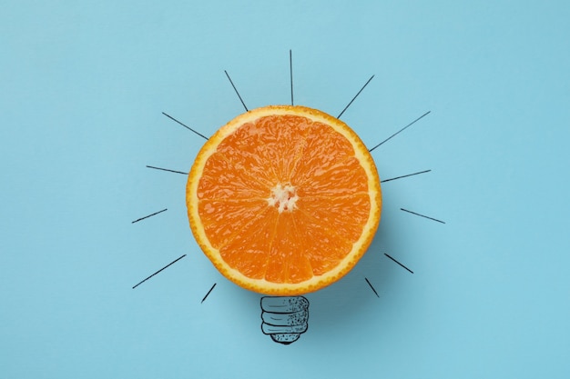 Photo orange light bulb on blue background, close up.