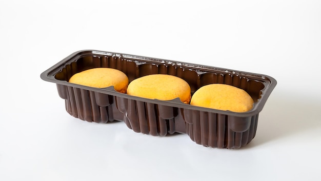 Biscotti macaron arancioni in scatola su sfondo bianco