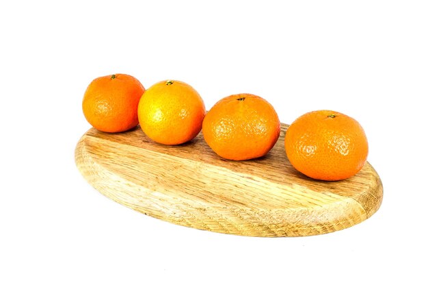 Orange mandarins or tangerines on cutting board isolated on white background Closeup photos of fresh citrus fruit