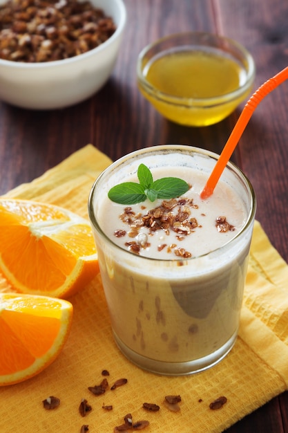 Orange milk shake with granola and mint