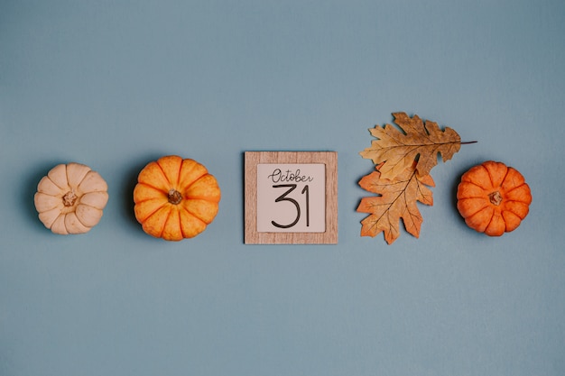 Фото Оранжевые мини тыквы и календарная дата в деревянной рамке