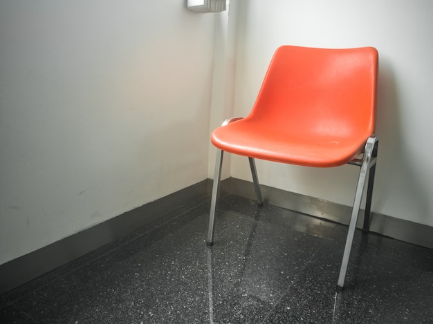  orange modern chair with a wall background