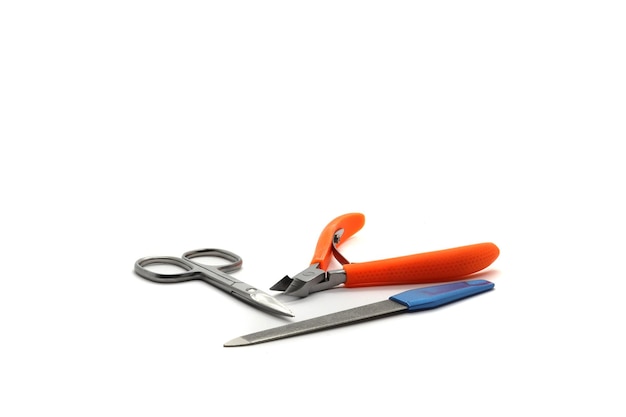 orange nail clippers scissors and nail file on a white background