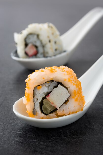 orange and orange sushi on spoon and black