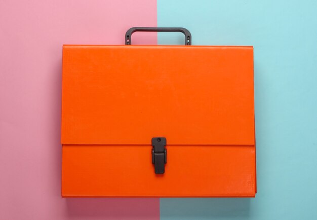 Orange paper case on pink blue pastel.