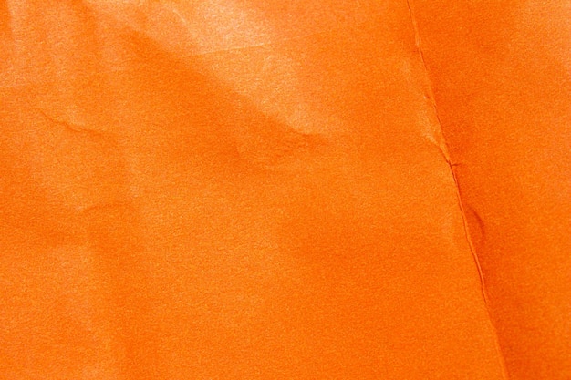 Photo an orange paper that is wrinkled and has a rough texture.