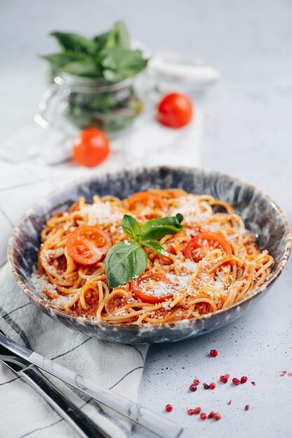 Photo orange pasta with tomatoes and sauce in a plate on a table