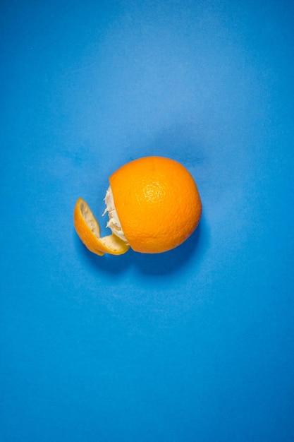 Orange in a peel on a blue background