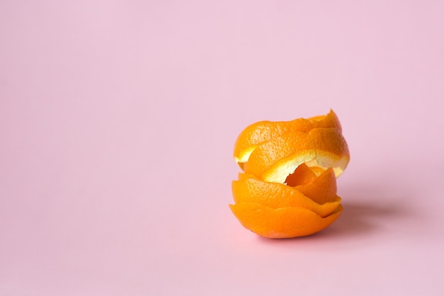 Photo orange peel on pink background as a symbol of recycling circulate economy