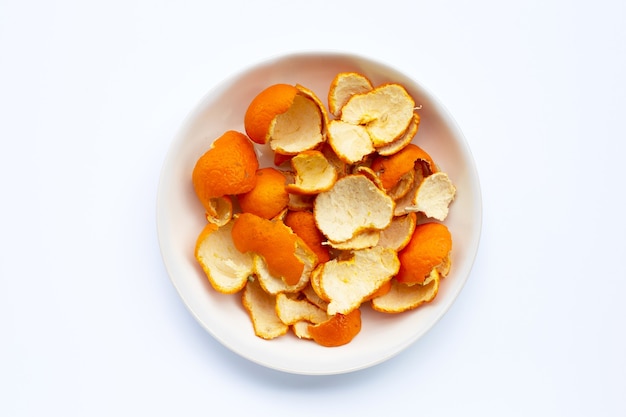 Orange peels in plate on white surface