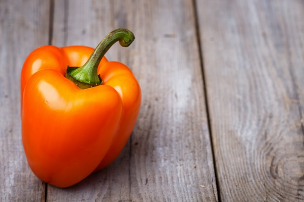 Orange pepper  on a wooden background