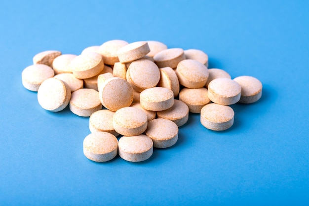 Orange pills vitamin C pills on blue background