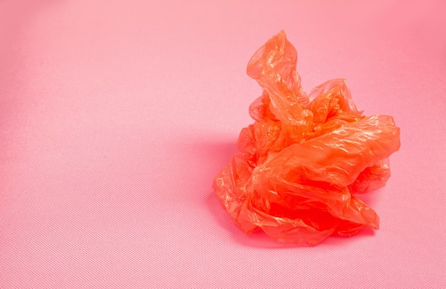 Оранжевый полиэтиленовый пакет на розовом фоне