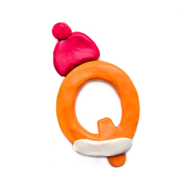 Orange plasticine letter P of the alphabet in a red winter hat on a white background