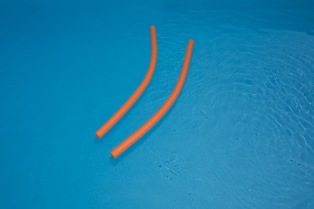 Orange pool float, ring floating in a refreshing blue swimming pool