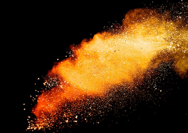 Photo orange powder explosion isolated on black  background