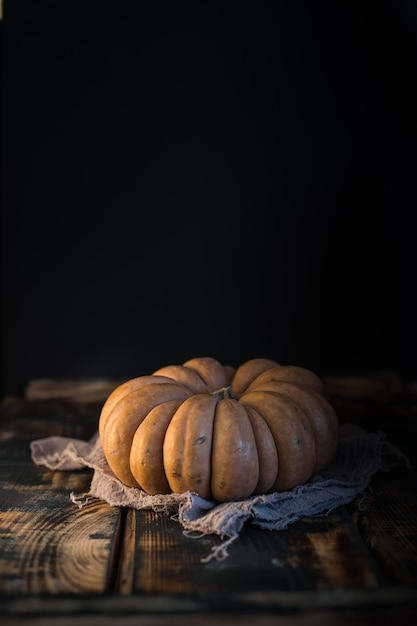 Foto zucca arancione sullo sfondo scuro messa a fuoco selettiva