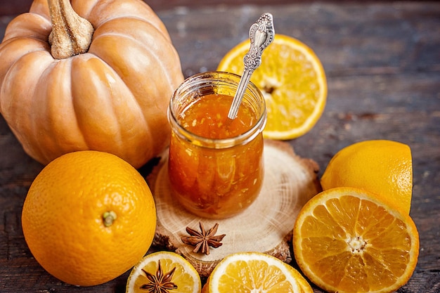 Orange pumpkin and ginger jam on a wooden background